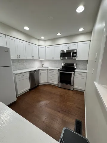 a kitchen with stainless steel appliances granite countertop a refrigerator and a stove top oven