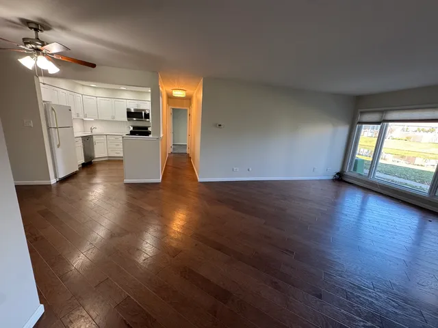 a view of a kitchen with a fridge wooden floor and a kitchen