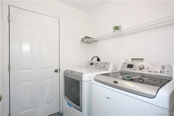 a view of washer and dryer with kitchen in the background