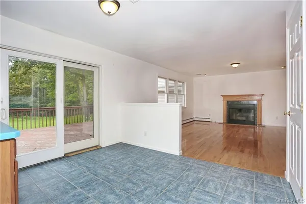 a view of empty room with wooden floor and fireplace
