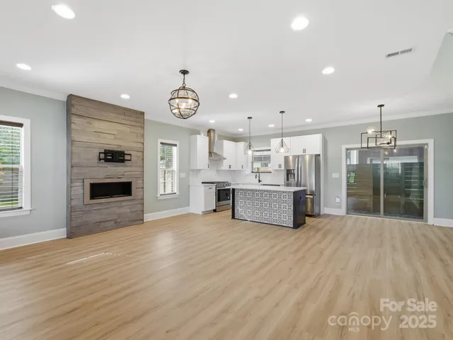 a large kitchen with a lot of kitchen and a dishwasher with wooden floor