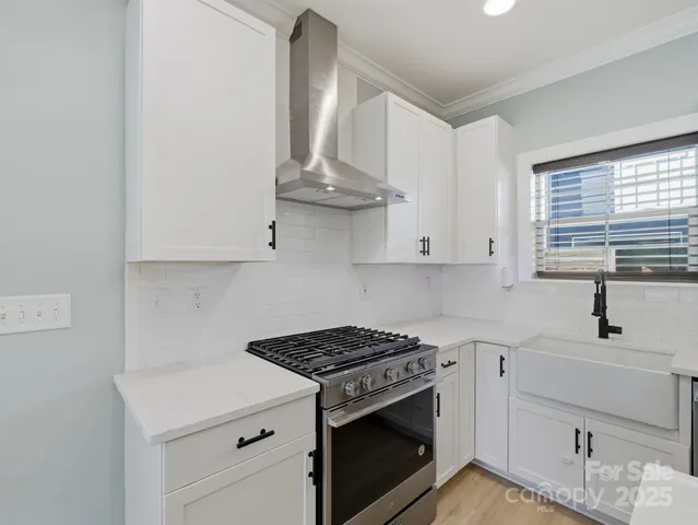 a kitchen with stainless steel appliances a sink stove and cabinets