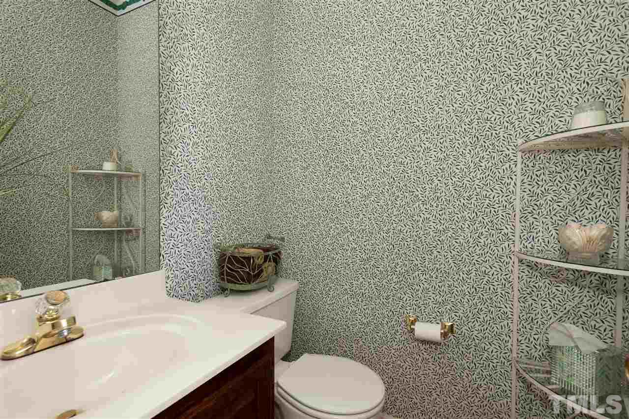5817 Raddington Street Raleigh, NC 27613 - Photo 12 of 25 a bathroom with a toilet a sink and mirror