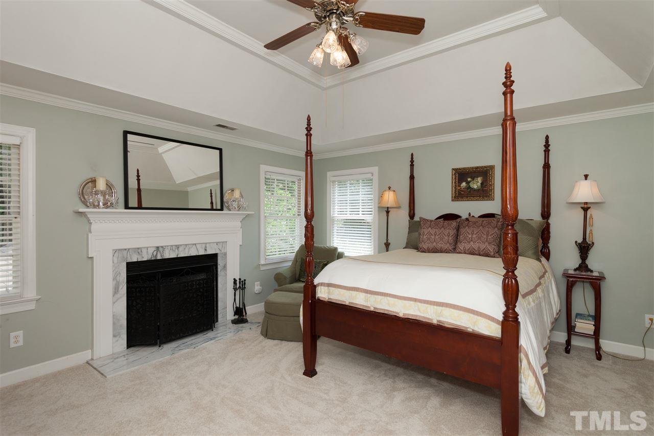 5817 Raddington Street Raleigh, NC 27613 - Photo 13 of 25 a bedroom with a bed and a fireplace