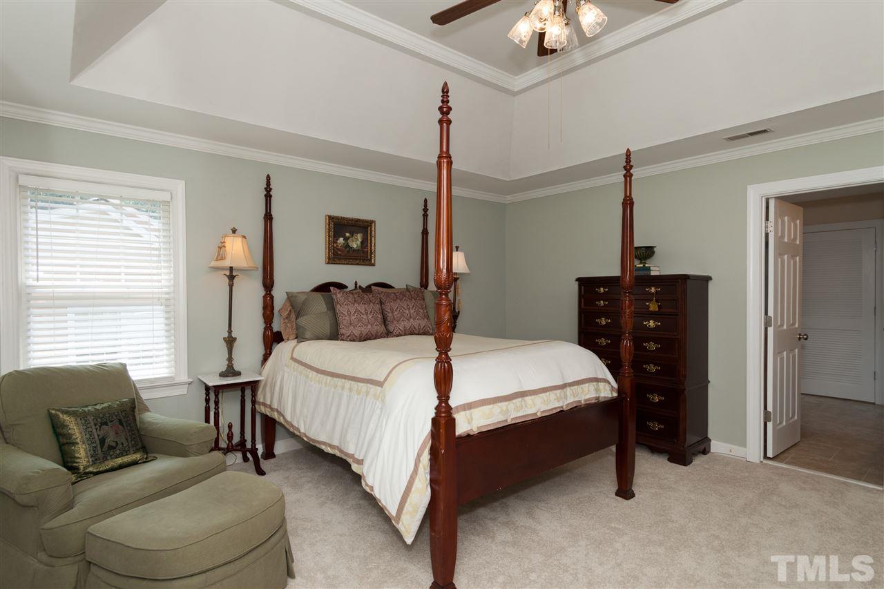 5817 Raddington Street Raleigh, NC 27613 - Photo 14 of 25 a bedroom with a bed and dresser with chandelier