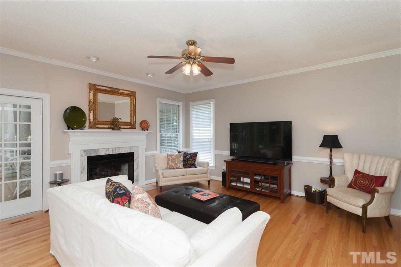 5817 Raddington Street Raleigh, NC 27613 - Photo 8 of 25 a living room with furniture a flat screen tv and a fireplace