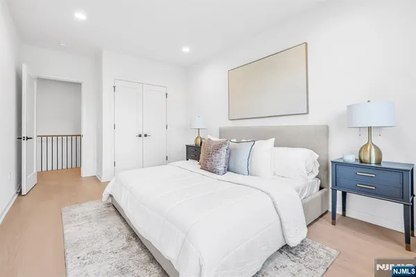 a bedroom with a bed and a lamp on dresser