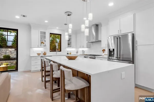 a kitchen with stainless steel appliances a table chairs and refrigerator