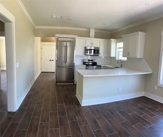 a kitchen with wooden floor and appliances