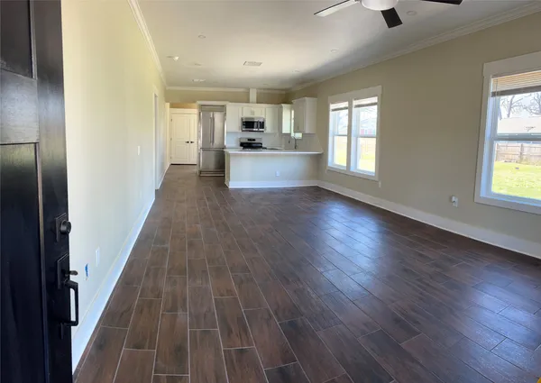 an empty room with wooden floor and windows