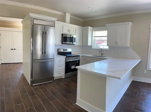 a kitchen with stainless steel appliances a refrigerator microwave and sink