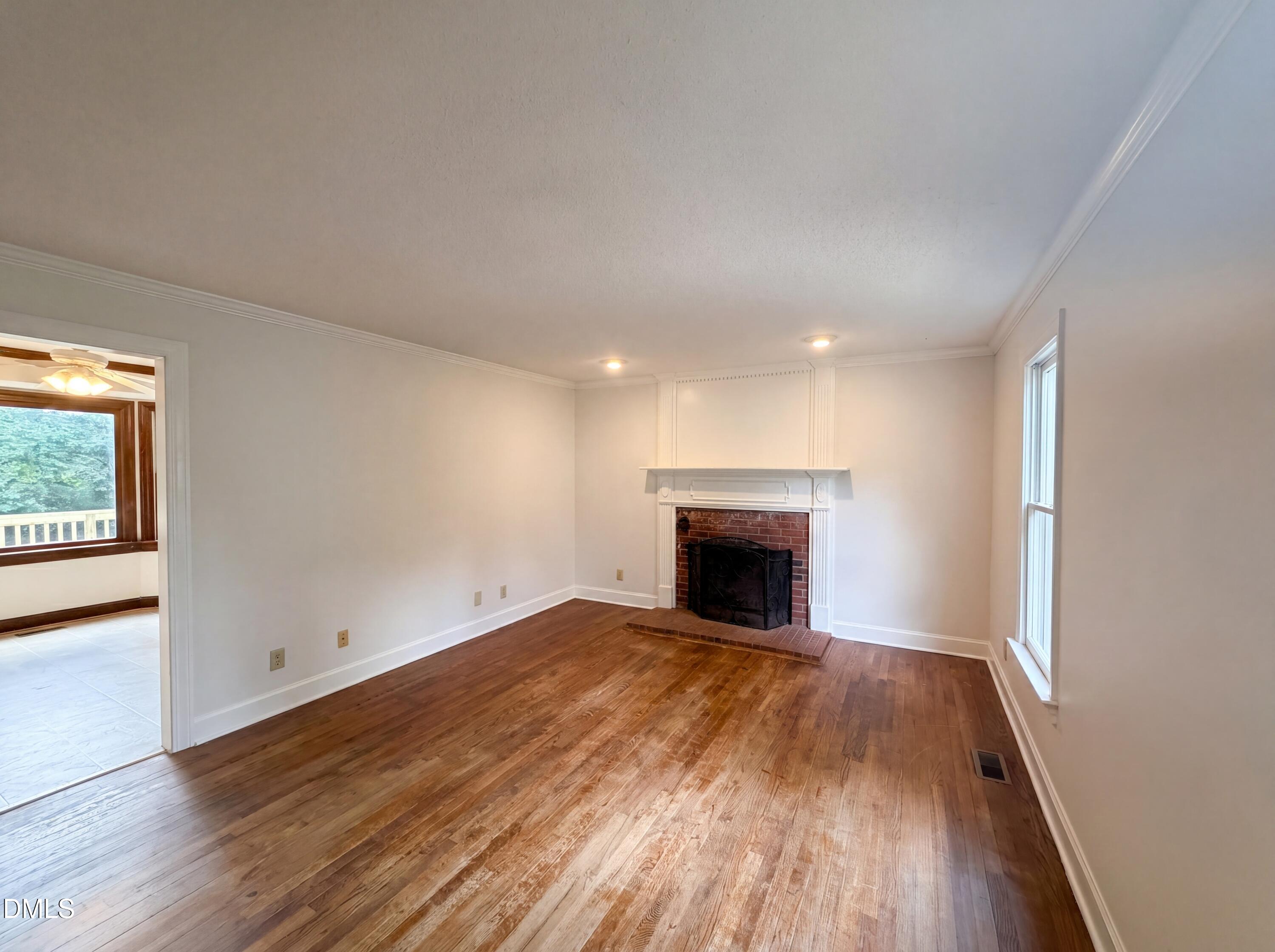 3921 Iron Horse Road Raleigh, NC 27616 - Photo 2 of 20 a view of empty room with wooden floor and fireplace