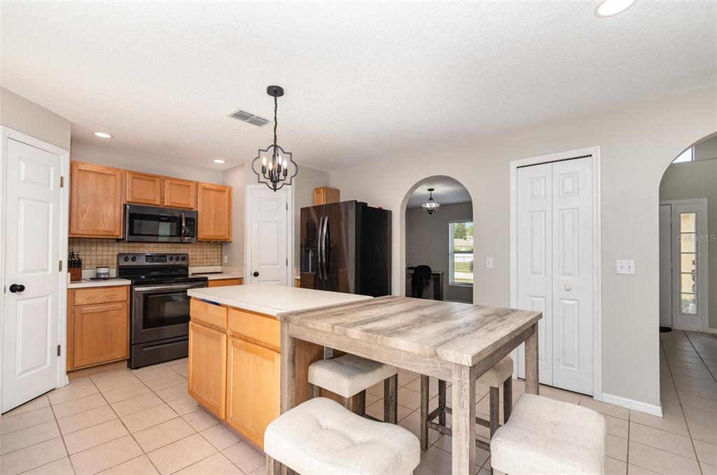 149 Circle Hill Road Sanford, FL 32746 - Photo 4 of 30 a kitchen that has a kitchen island wooden cabinets and stainless steel appliances