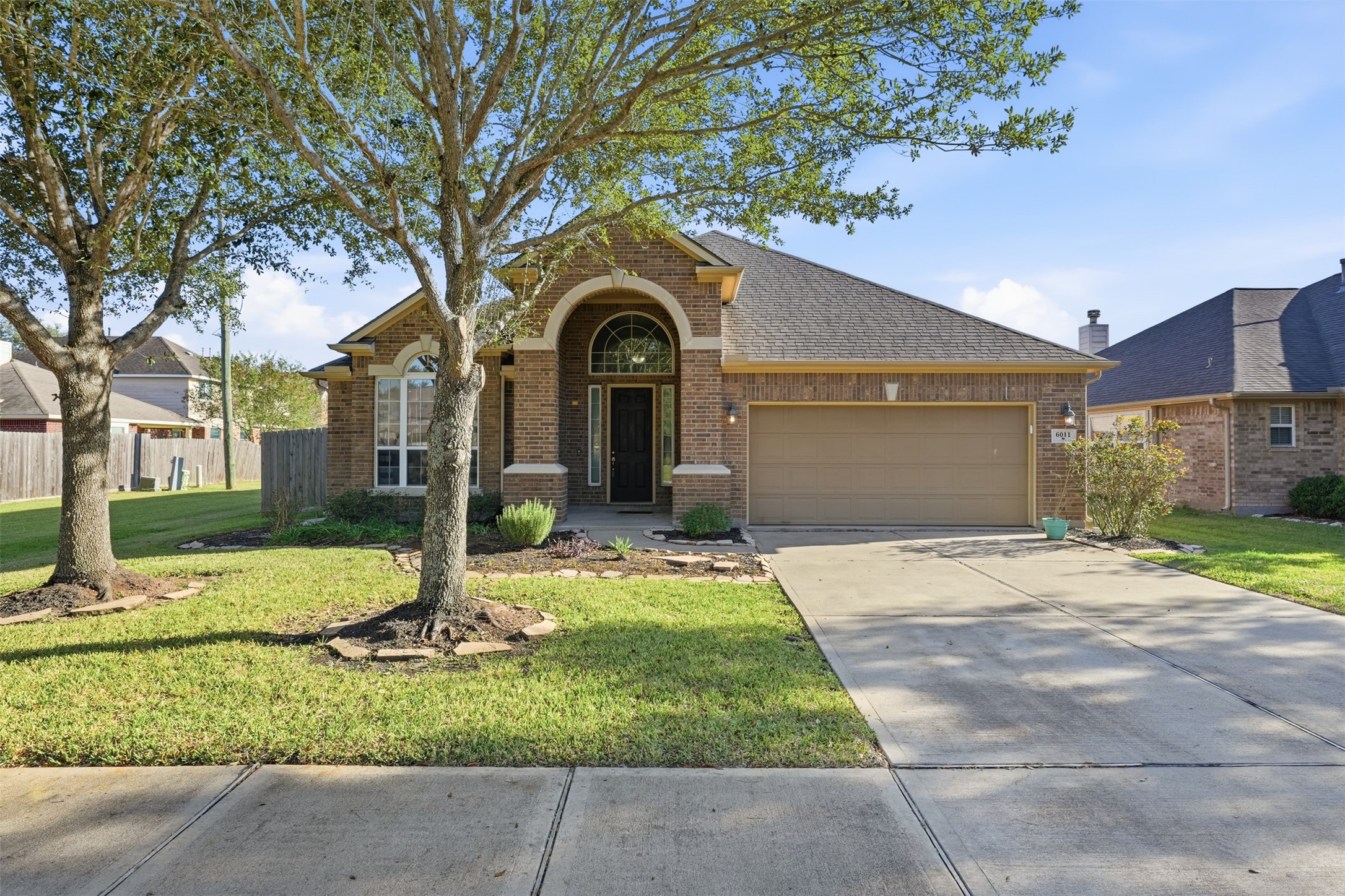 6011 Watford Bend Rosenberg, TX 77471 - Photo 3 of 48 a front view of a house with a garden and trees