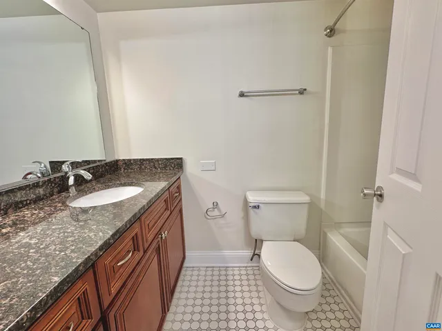 a bathroom with a granite countertop sink toilet and a shower