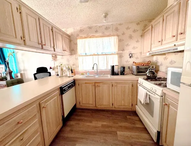 a kitchen with sink a stove and cabinets