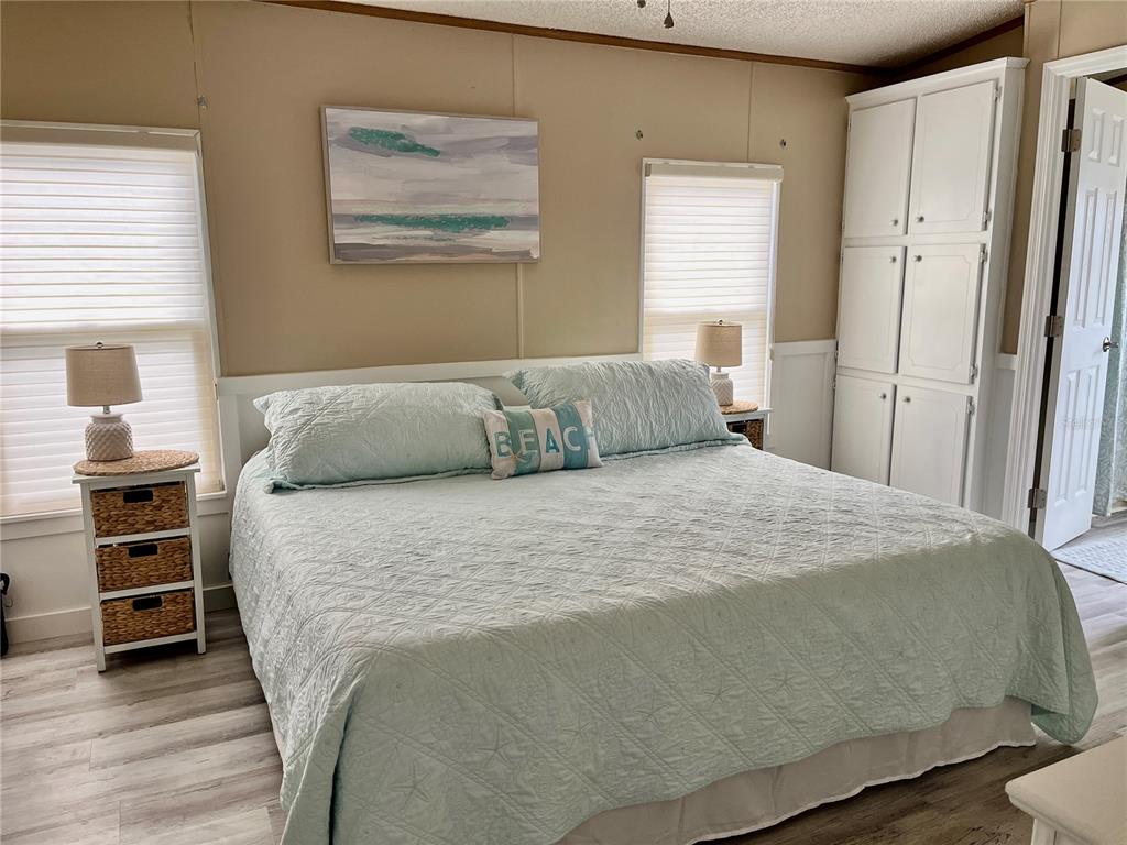 6803 Mt Pleasant Road Northeast, Unit 33 St. Petersburg, FL 33702 - Photo 11 of 28 a bedroom with a bed and wooden floor