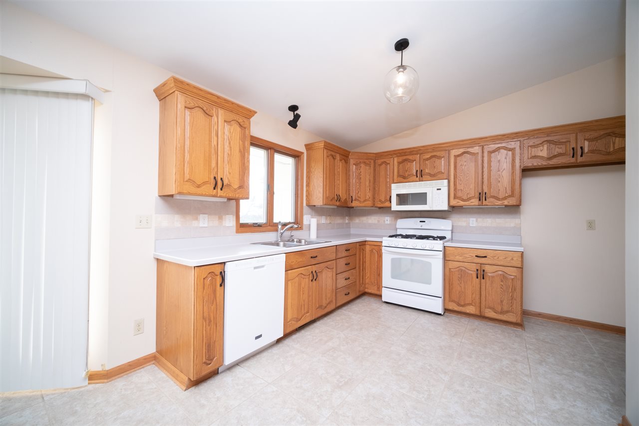 7290 Stephens Road Rockton, IL 61072 - Photo 10 of 30 a kitchen with granite countertop white cabinets and white appliances
