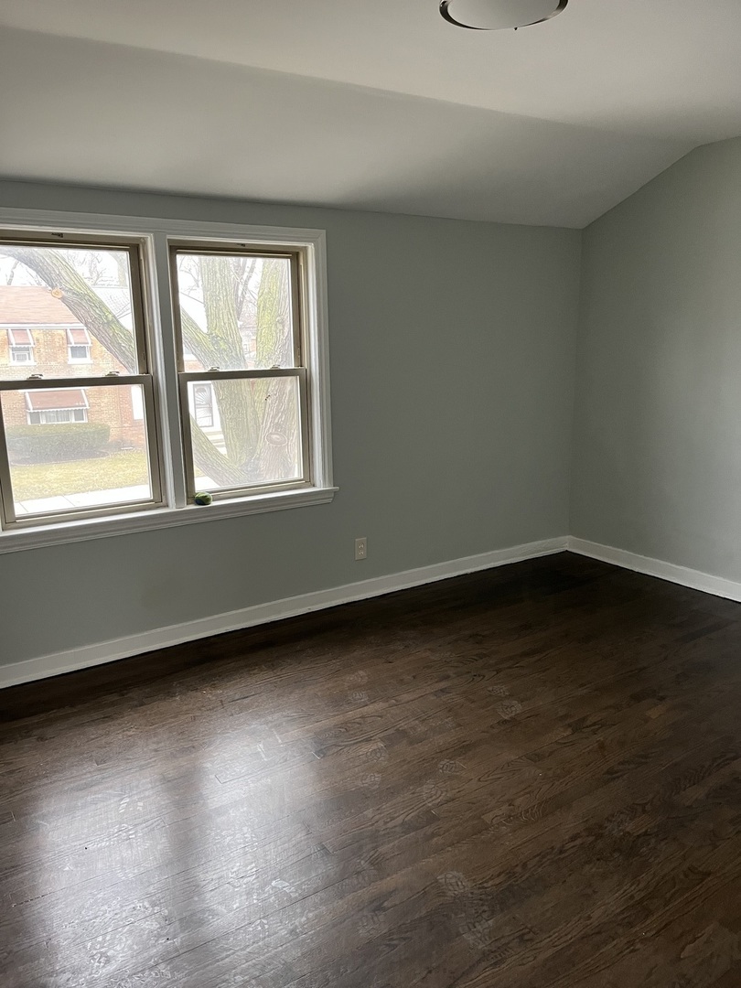 9621 South Yates Boulevard Chicago, IL 60617 - Photo 5 of 6 an empty room with wooden floor and windows