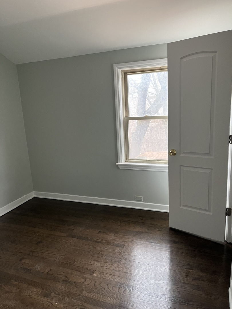 9621 South Yates Boulevard Chicago, IL 60617 - Photo 6 of 6 an empty room with wooden floor and windows