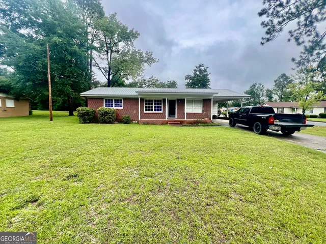 a view of a house with a patio and a yard