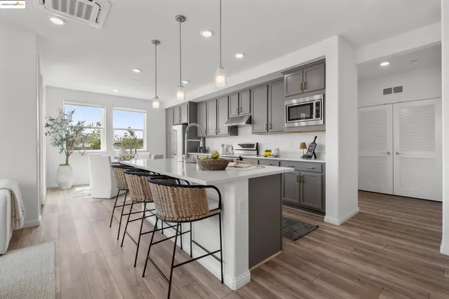 a kitchen with kitchen island a counter top space a sink stainless steel appliances and cabinets