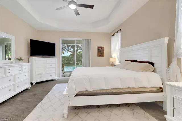 a spacious bedroom with a bed and a flat screen tv