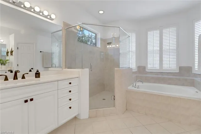 a bathroom with a double vanity sink large mirror and a bathtub