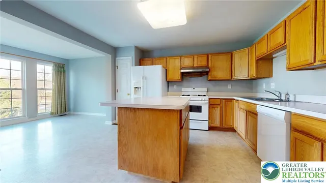 a kitchen with stainless steel appliances granite countertop a sink a stove cabinets counter space and a window