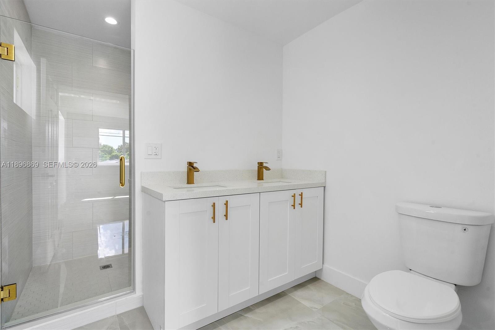 2926 Northwest 58th Street, Unit 2926 Miami, FL 33142 - Photo 20 of 28 a bathroom with a toilet sink and glass door