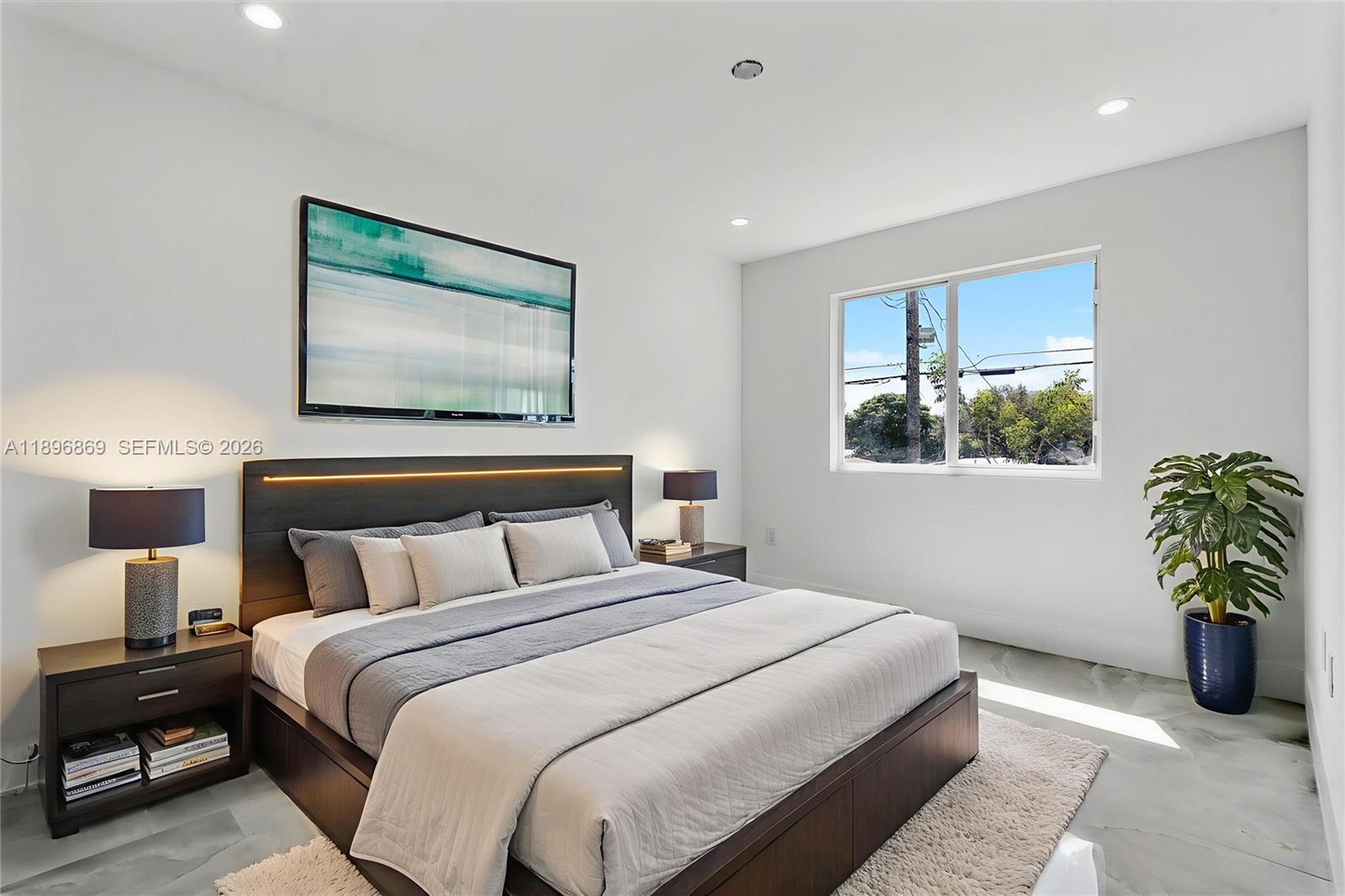 2926 Northwest 58th Street, Unit 2926 Miami, FL 33142 - Photo 4 of 28 a bedroom with a bed and a painting on the wall