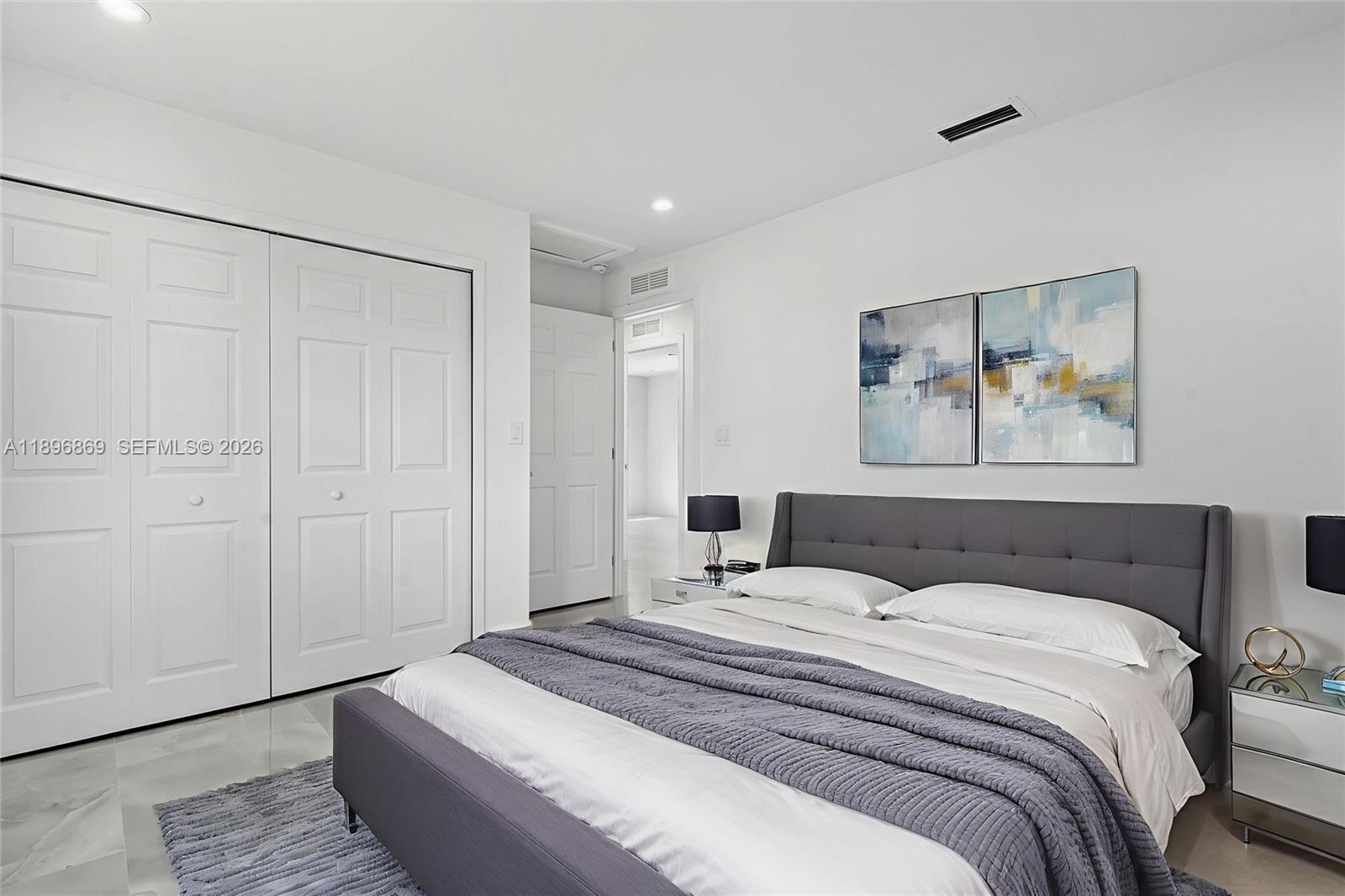 2926 Northwest 58th Street, Unit 2926 Miami, FL 33142 - Photo 5 of 28 a bedroom with a bed and a painting on the wall