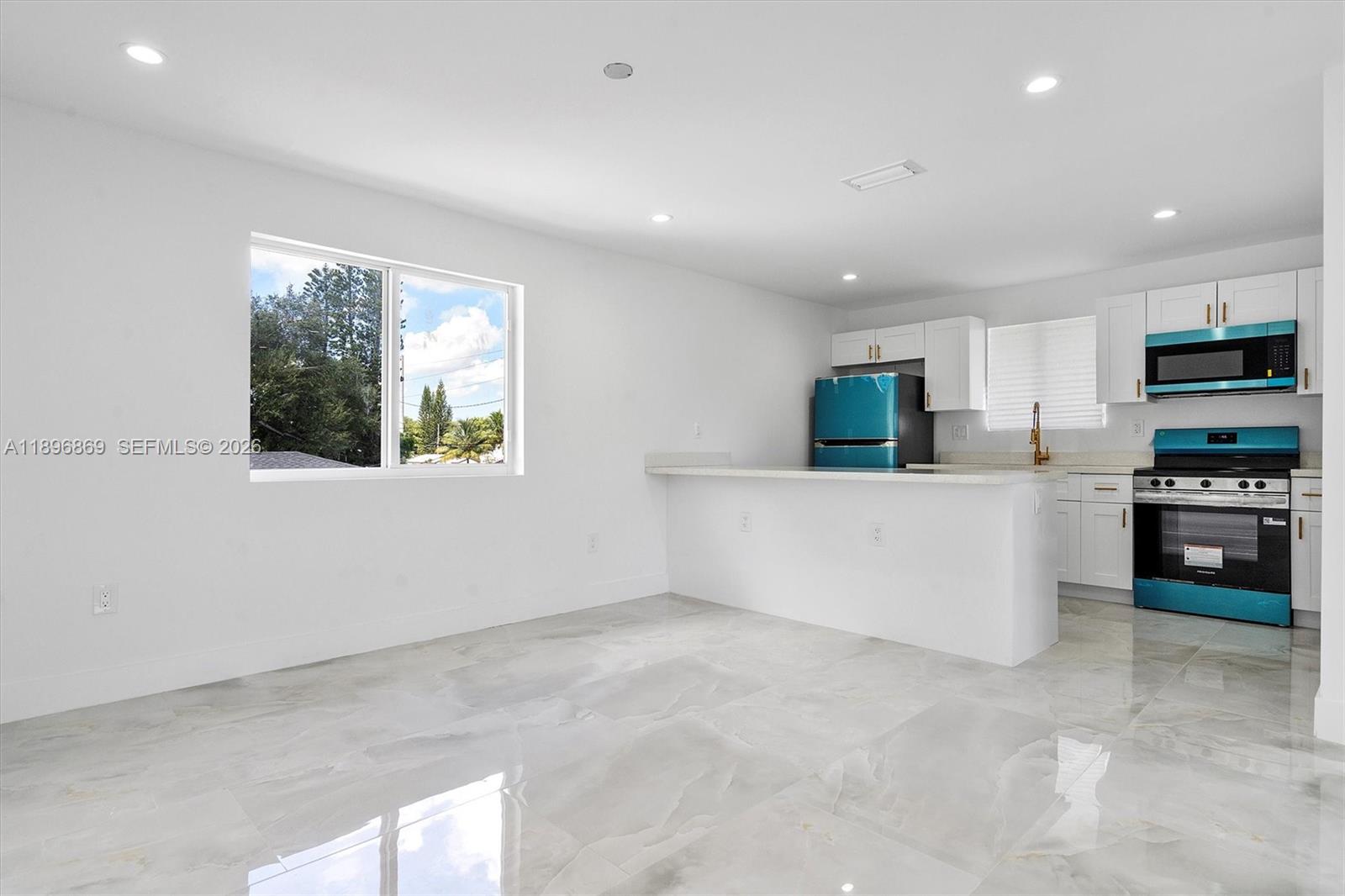 2926 Northwest 58th Street, Unit 2926 Miami, FL 33142 - Photo 7 of 28 a kitchen with stainless steel appliances a refrigerator sink and microwave