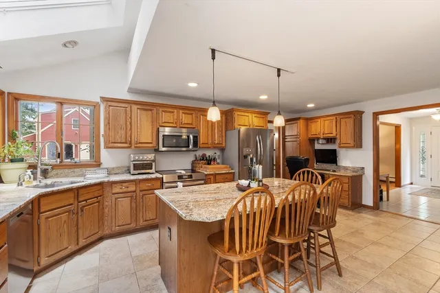 a kitchen with stainless steel appliances granite countertop a sink and a refrigerator