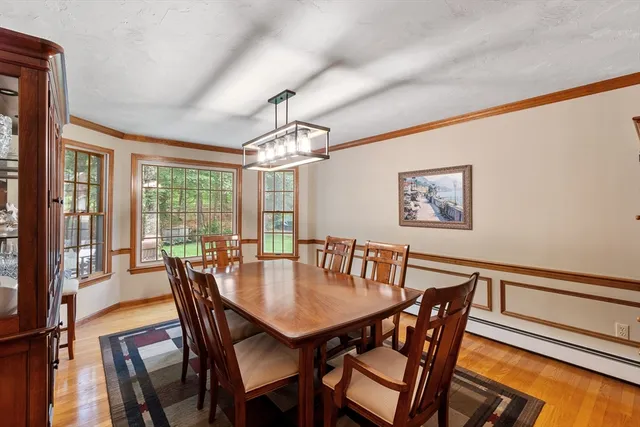 a view of a dining room with furniture a chandelier and wooden floor