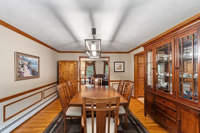 a view of a dining room with furniture a chandelier and wooden floor