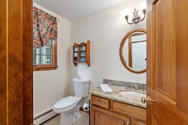 a bathroom with a granite countertop toilet and a sink