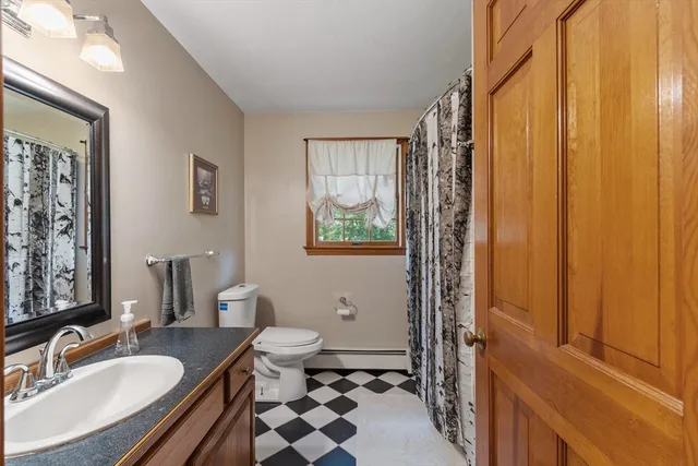 a bathroom with a granite countertop sink toilet a mirror a vanity and shower