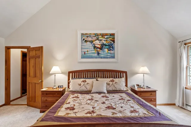 a bedroom with a bed a rug and wooden floor