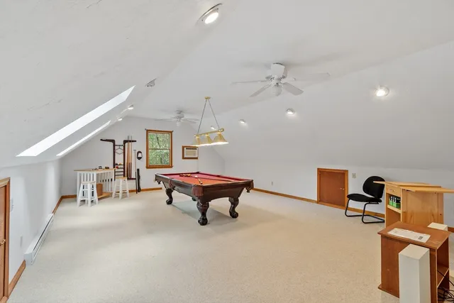 a room with pool table wooden floor and fan
