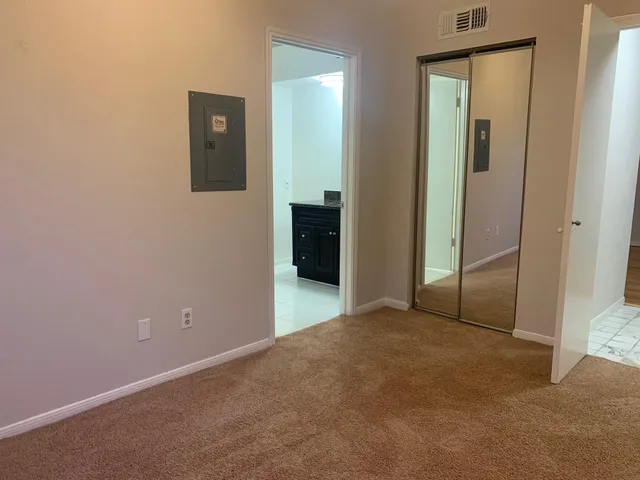 an empty room with closet and a bathroom