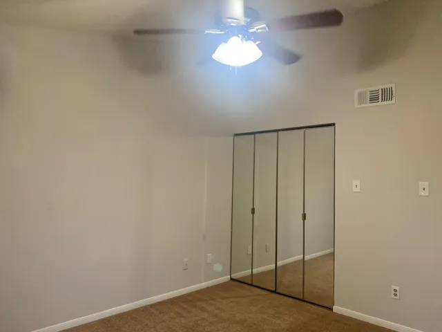 a view of a room with a chandelier fan
