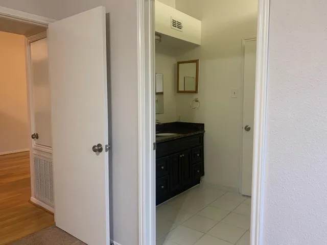 a bathroom with a granite countertop sink and a mirror