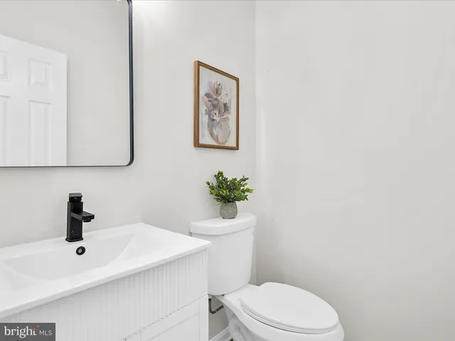 a bathroom with a toilet a sink and mirror
