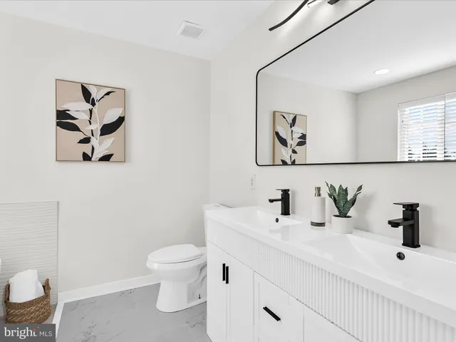 a bathroom with a toilet a sink and mirror