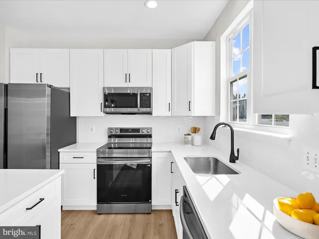 a kitchen with stainless steel appliances a stove a sink a microwave and cabinets