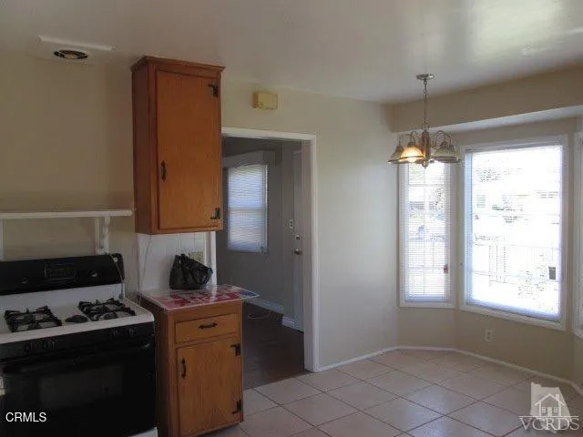 a kitchen with a stove a refrigerator and a window