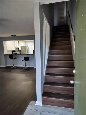a view of staircase and kitchen with wooden floor