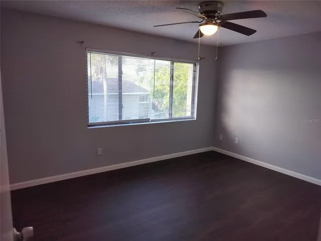 an empty room with a window and a fan