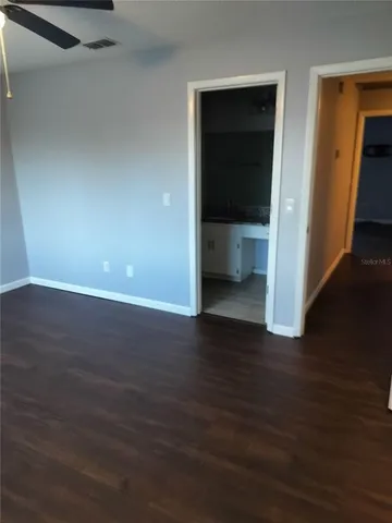 a view of an empty room with wooden floor & closet